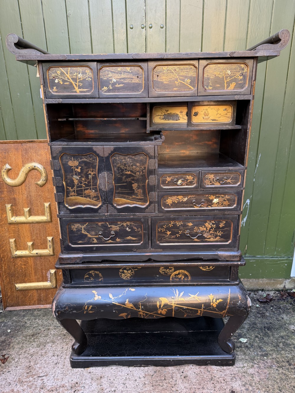 Late nineteenth-century Japanese Meiji period black lacquer shodana cabinet-on-stand with gold maki-e pictorial panels, asymmetrical shelves, and engraved metal fitments. View XXVI