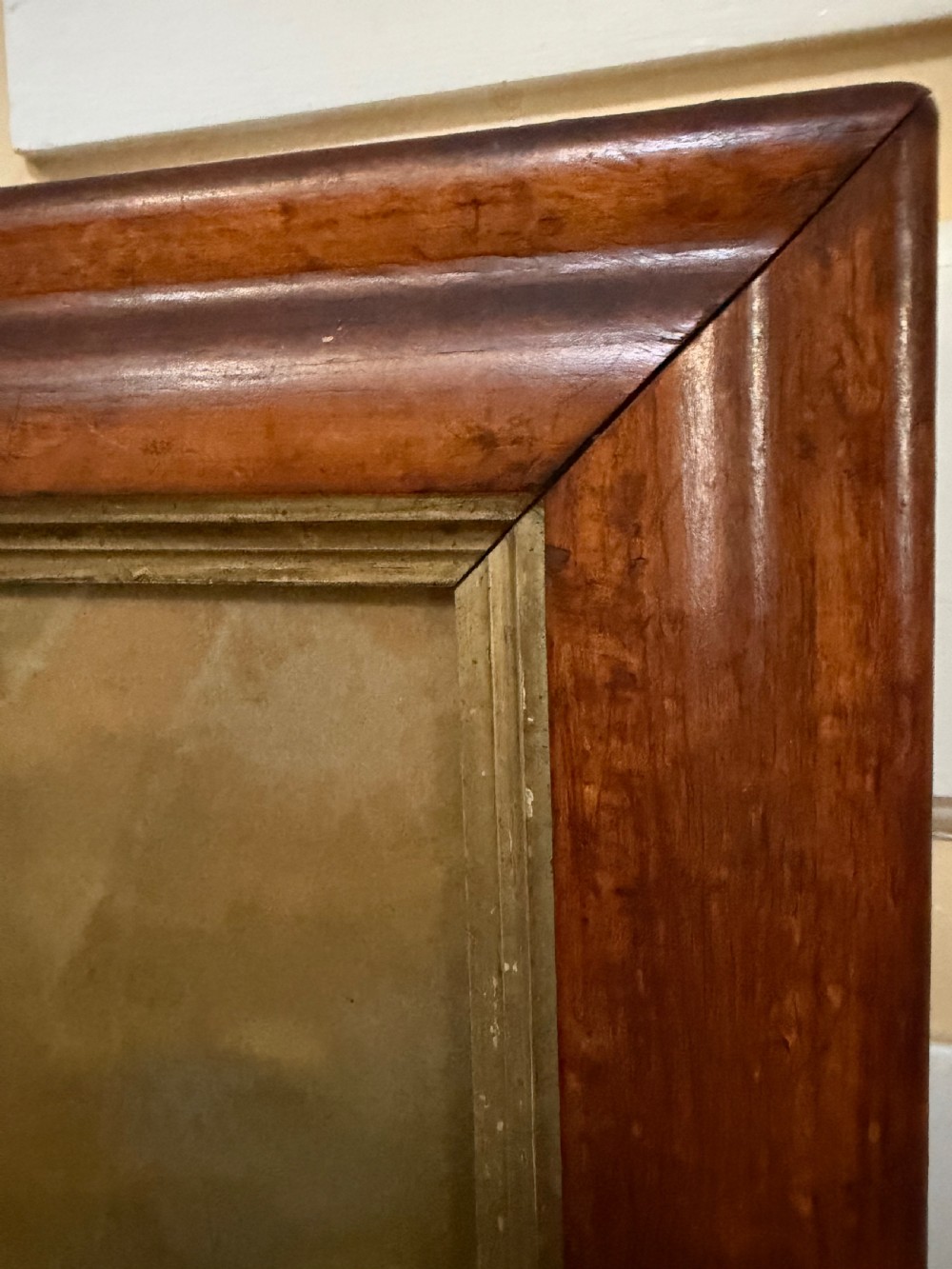 An early nineteenth-century rectangular maple-framed divided mirror featuring a reverse glass print of a naval engagement in the upper section and a reflective mirror below. View VIII
