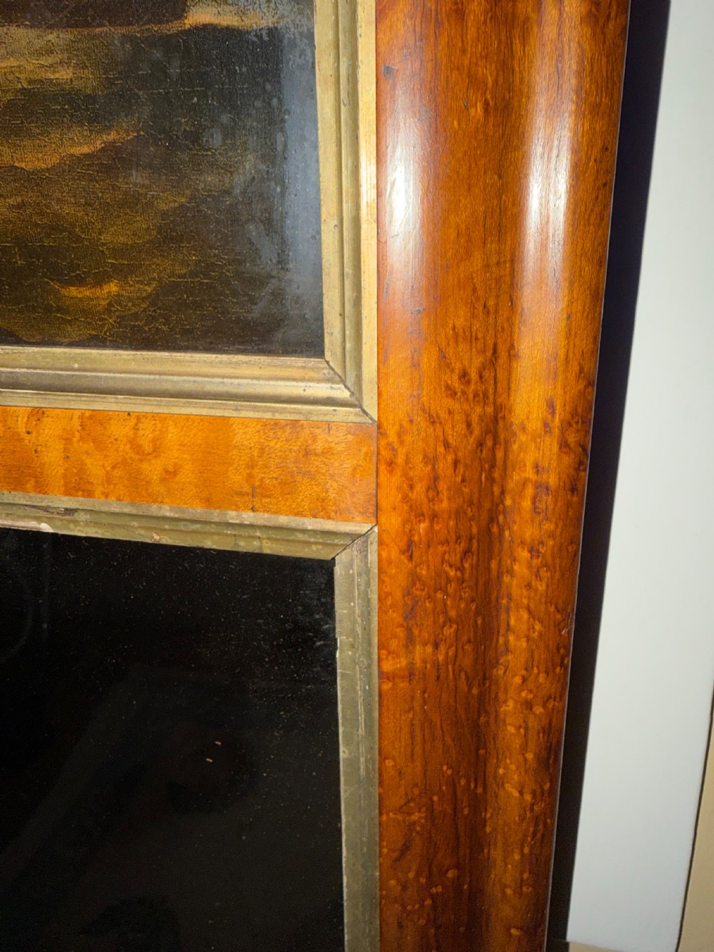 An early nineteenth-century rectangular maple-framed divided mirror featuring a reverse glass print of a naval engagement in the upper section and a reflective mirror below. View IX