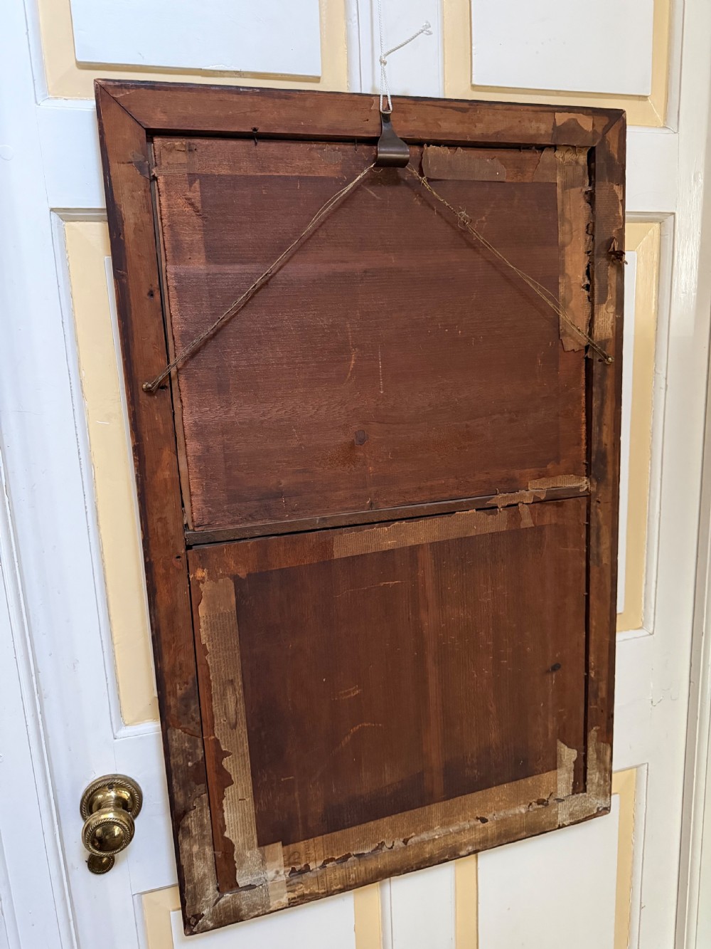 An early nineteenth-century rectangular maple-framed divided mirror featuring a reverse glass print of a naval engagement in the upper section and a reflective mirror below. View XIV