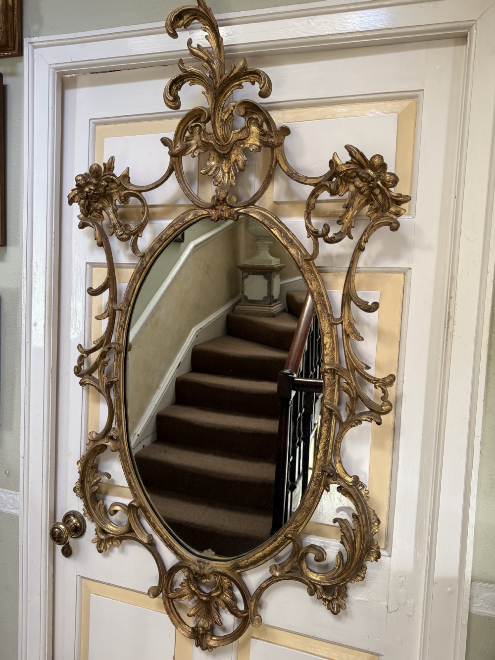 Flamboyant early C20th carved gilt-wood and composition rococo-style framed oval mirror of C18th period design in the manner of Thomas Chippendale. View XVII