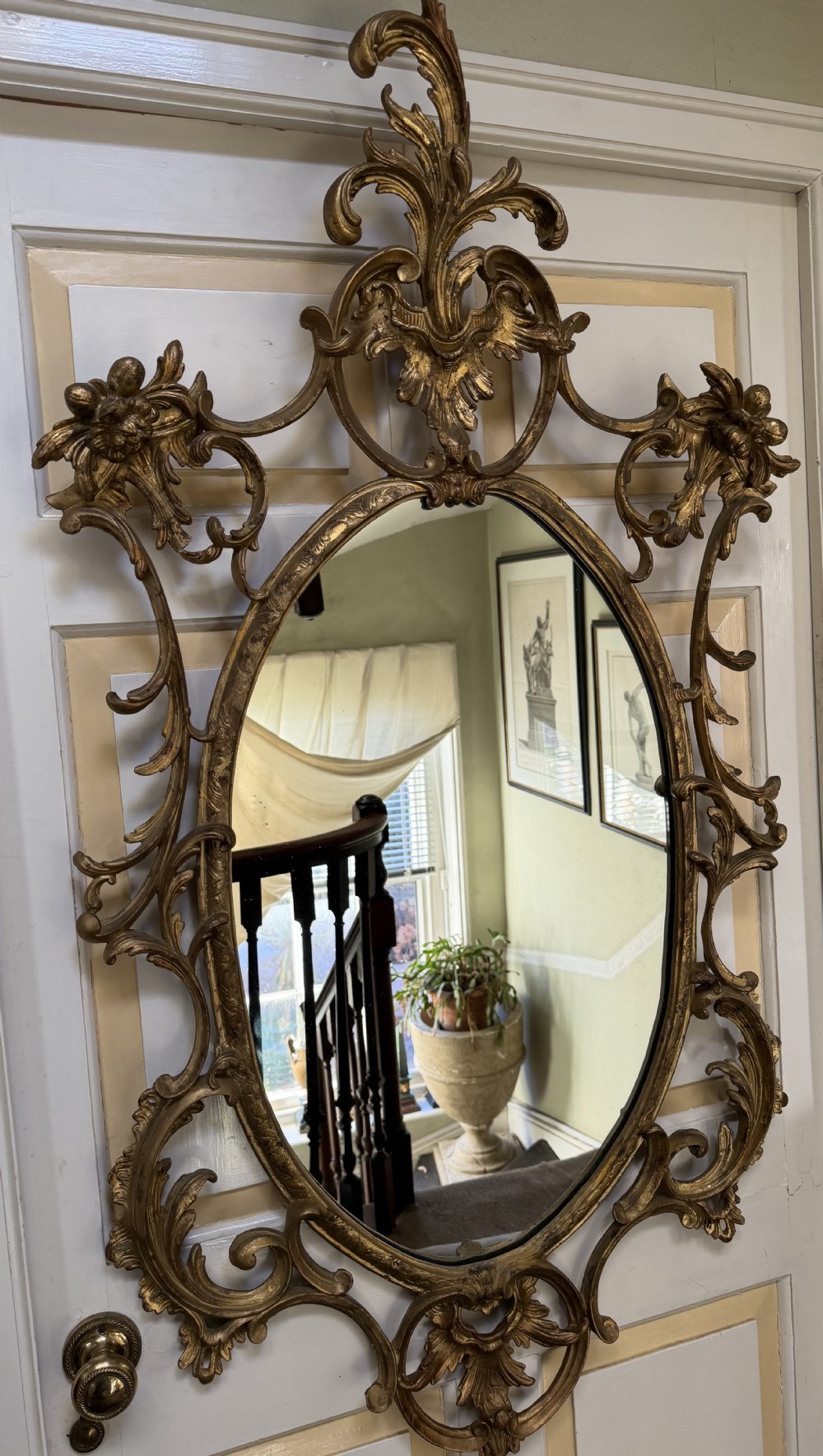Flamboyant early C20th carved gilt-wood and composition rococo-style framed oval mirror of C18th period design in the manner of Thomas Chippendale.