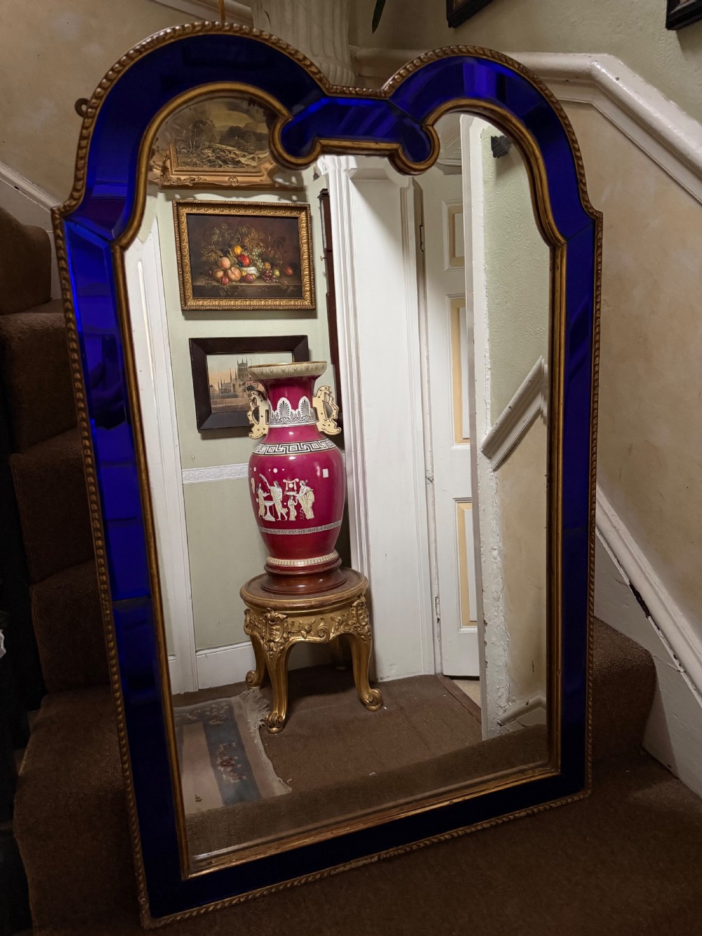 A late 19th-century wall mirror featuring a shaped arched top, cobalt blue glass margin borders, and an ornate gilded inner and outer moulding. View II