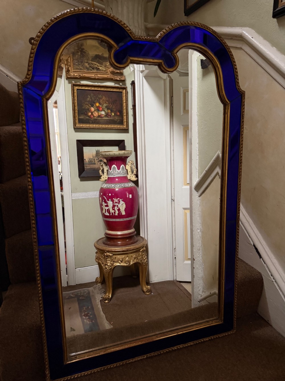 A late 19th-century wall mirror featuring a shaped arched top, cobalt blue glass margin borders, and an ornate gilded inner and outer moulding. View IV