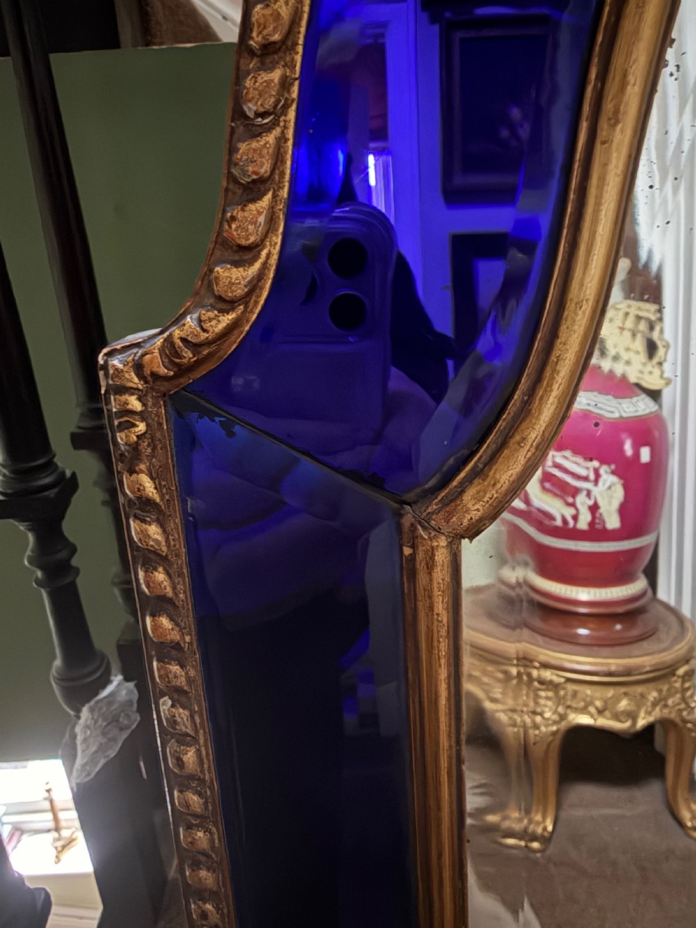 A late 19th-century wall mirror featuring a shaped arched top, cobalt blue glass margin borders, and an ornate gilded inner and outer moulding. View VII