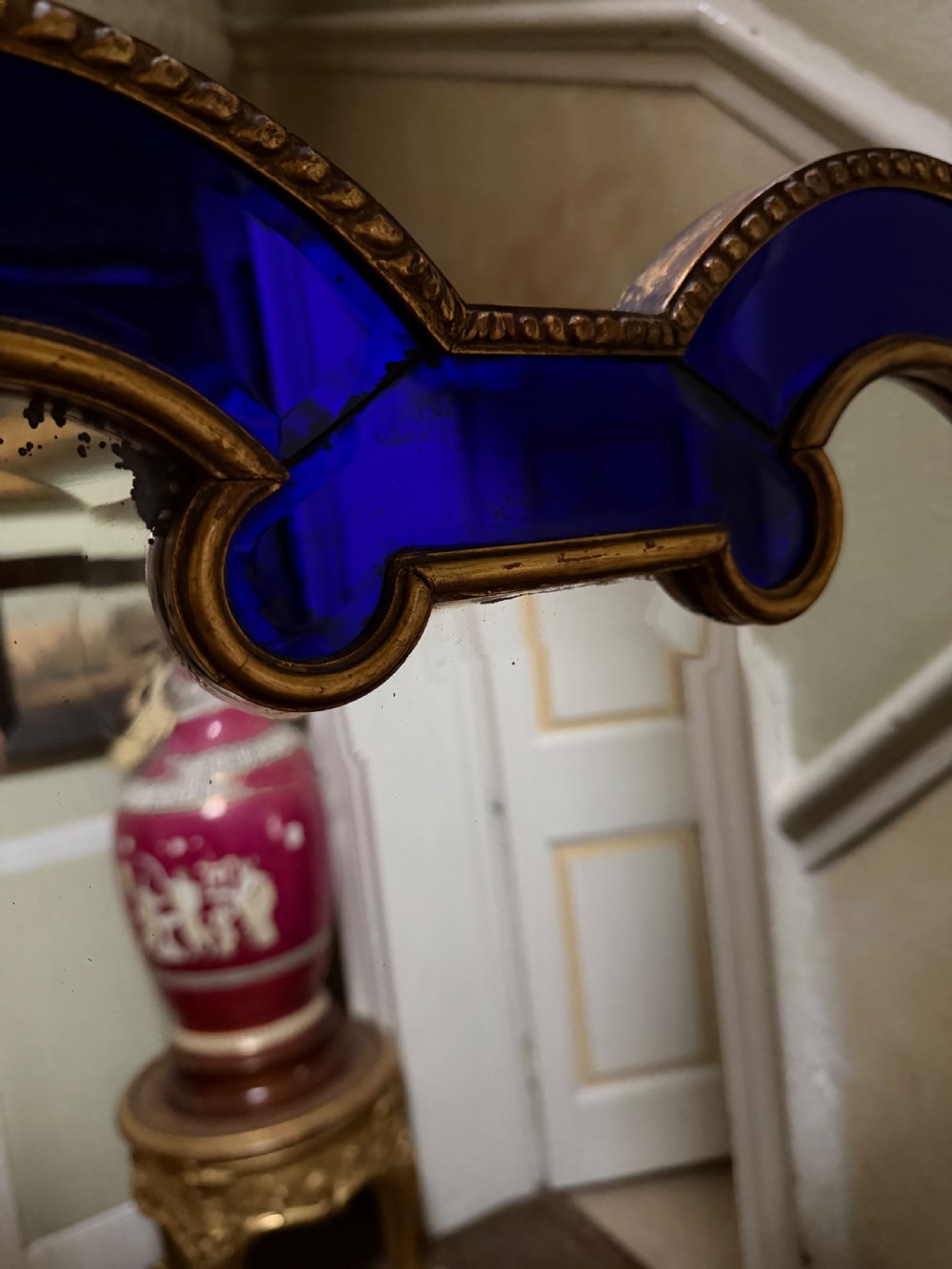 A late 19th-century wall mirror featuring a shaped arched top, cobalt blue glass margin borders, and an ornate gilded inner and outer moulding. View VIII