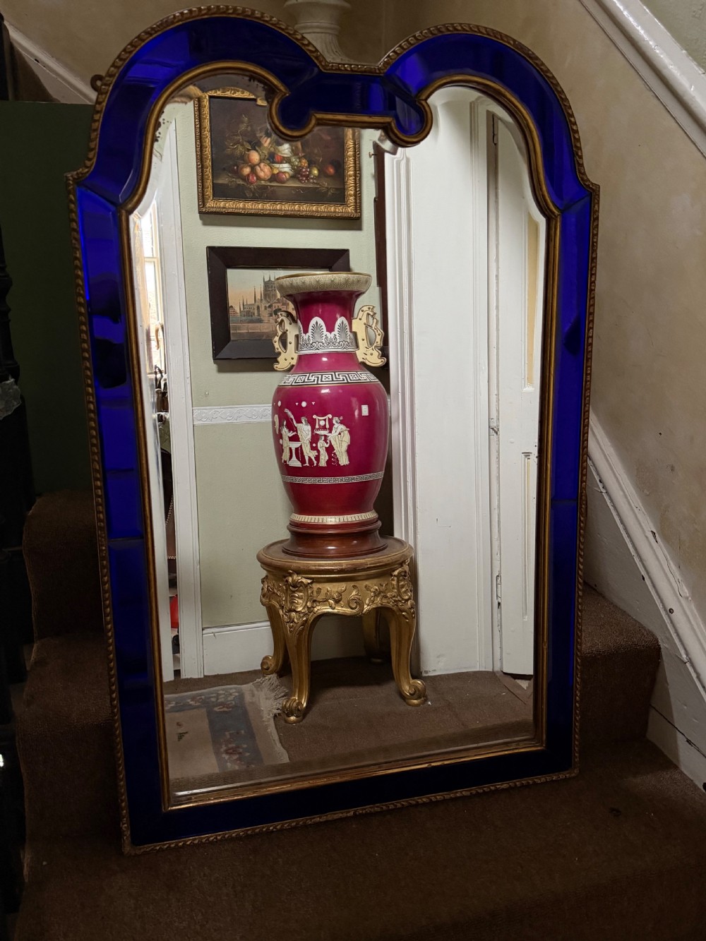 A late 19th-century wall mirror featuring a shaped arched top, cobalt blue glass margin borders, and an ornate gilded inner and outer moulding. View X