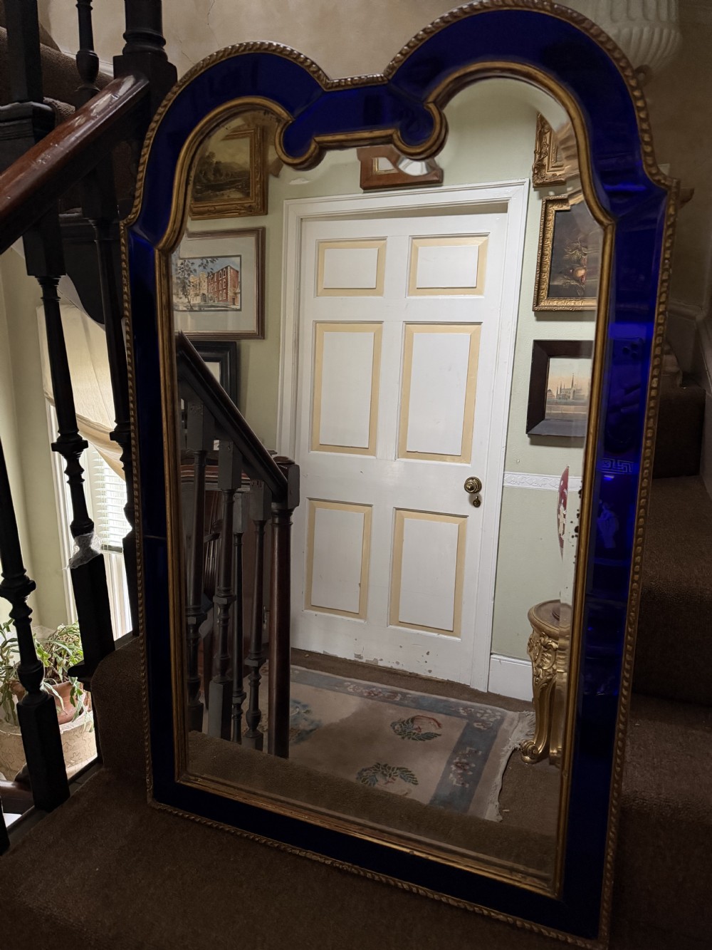 A late 19th-century wall mirror featuring a shaped arched top, cobalt blue glass margin borders, and an ornate gilded inner and outer moulding. View IX