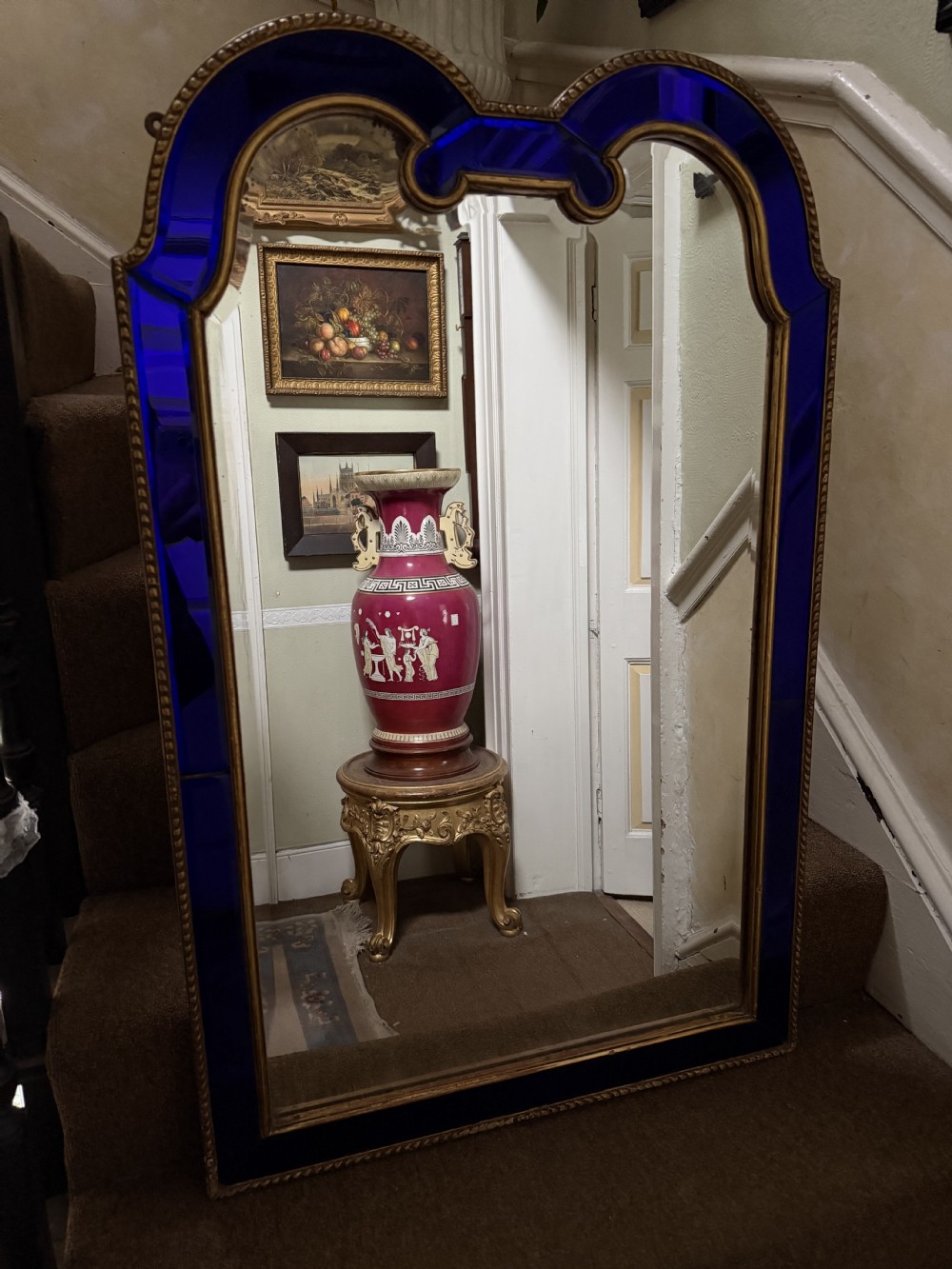 A late 19th-century wall mirror featuring a shaped arched top, cobalt blue glass margin borders, and an ornate gilded inner and outer moulding. View XV