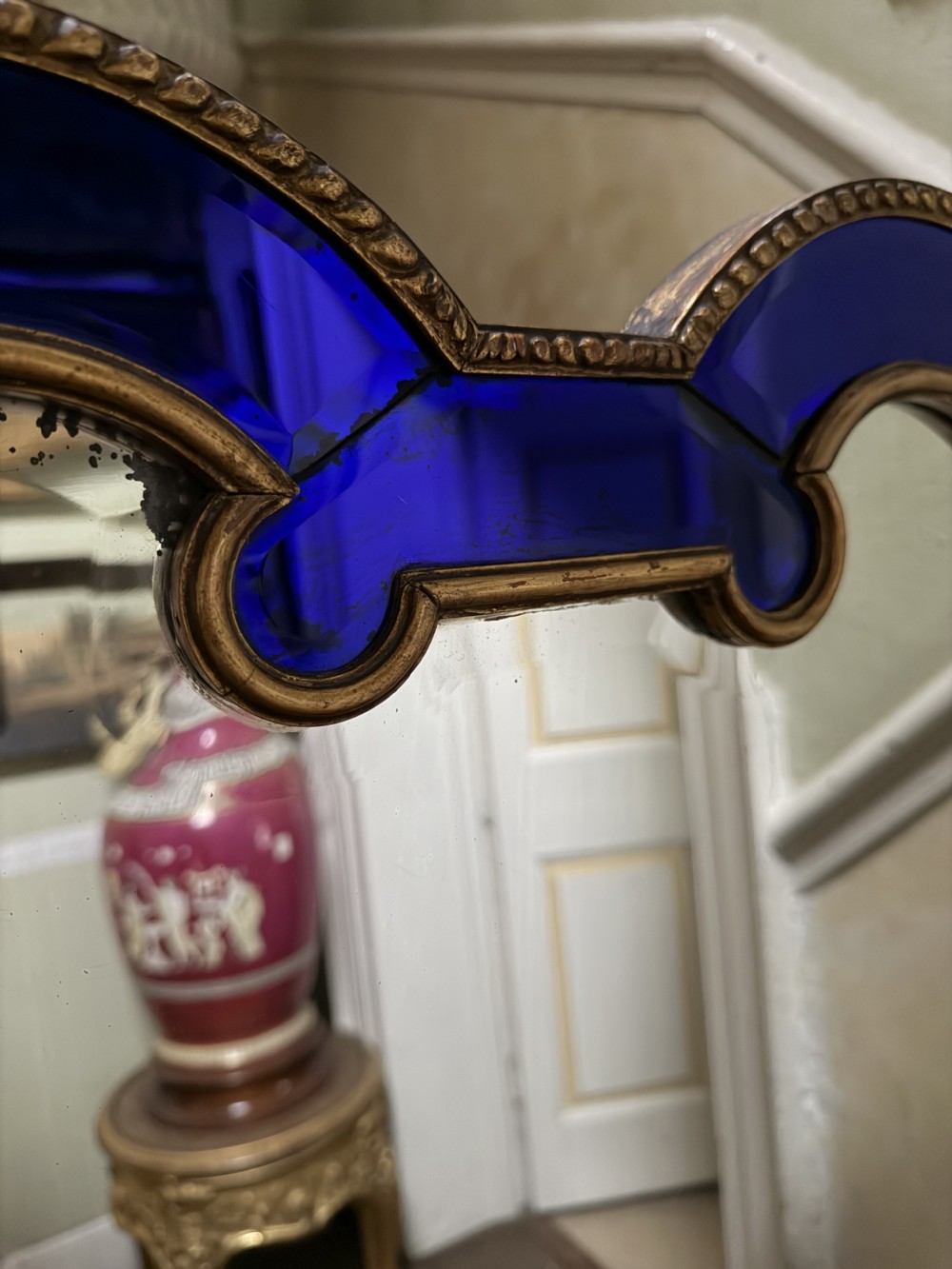 A late 19th-century wall mirror featuring a shaped arched top, cobalt blue glass margin borders, and an ornate gilded inner and outer moulding. View XVI