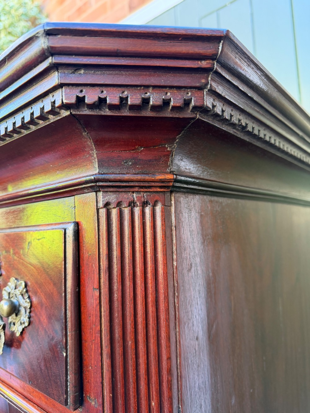 A mid-18th century George II red walnut chest-on-chest featuring a dentil moulded cornice, brass swan-neck handles, and bracket feet. View II