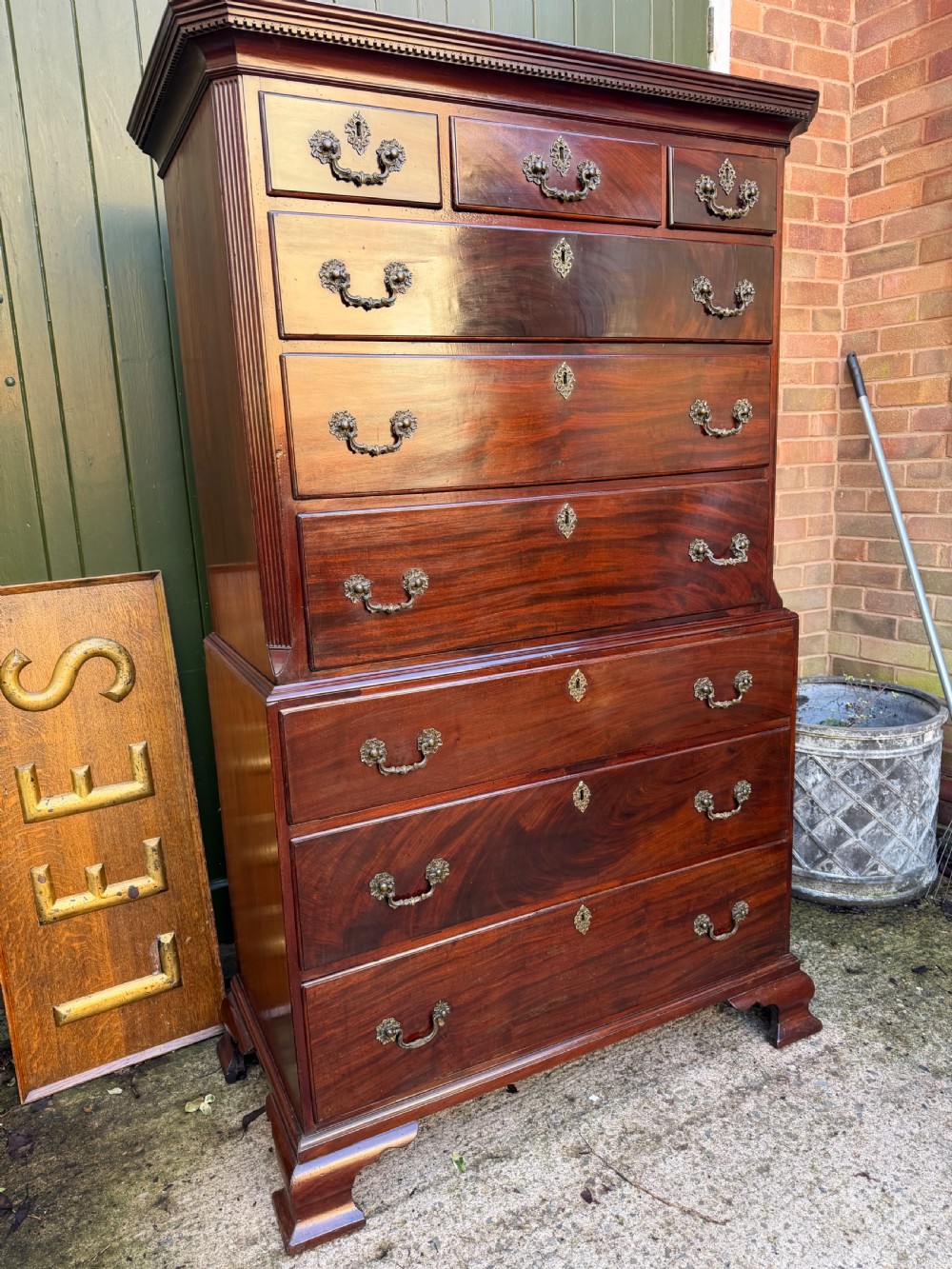 A mid-18th century George II red walnut chest-on-chest featuring a dentil moulded cornice, brass swan-neck handles, and bracket feet. View III