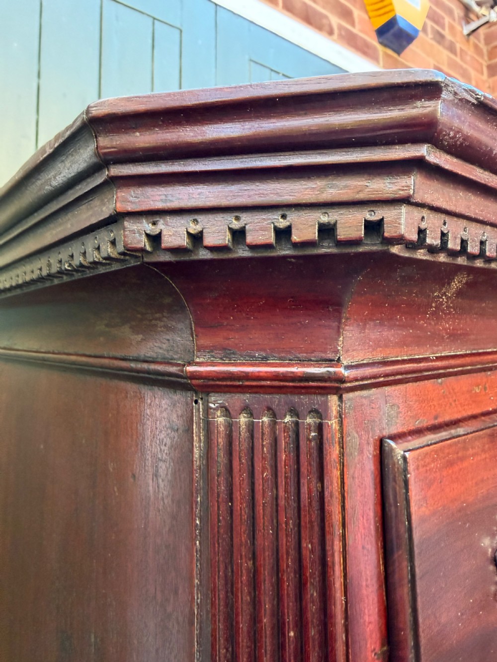 A mid-18th century George II red walnut chest-on-chest featuring a dentil moulded cornice, brass swan-neck handles, and bracket feet. View IX
