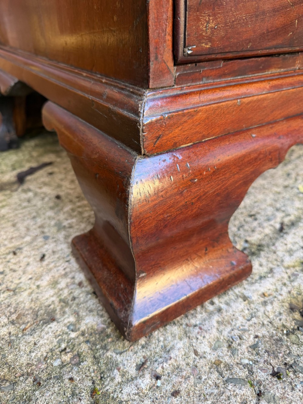 A mid-18th century George II red walnut chest-on-chest featuring a dentil moulded cornice, brass swan-neck handles, and bracket feet. View XV