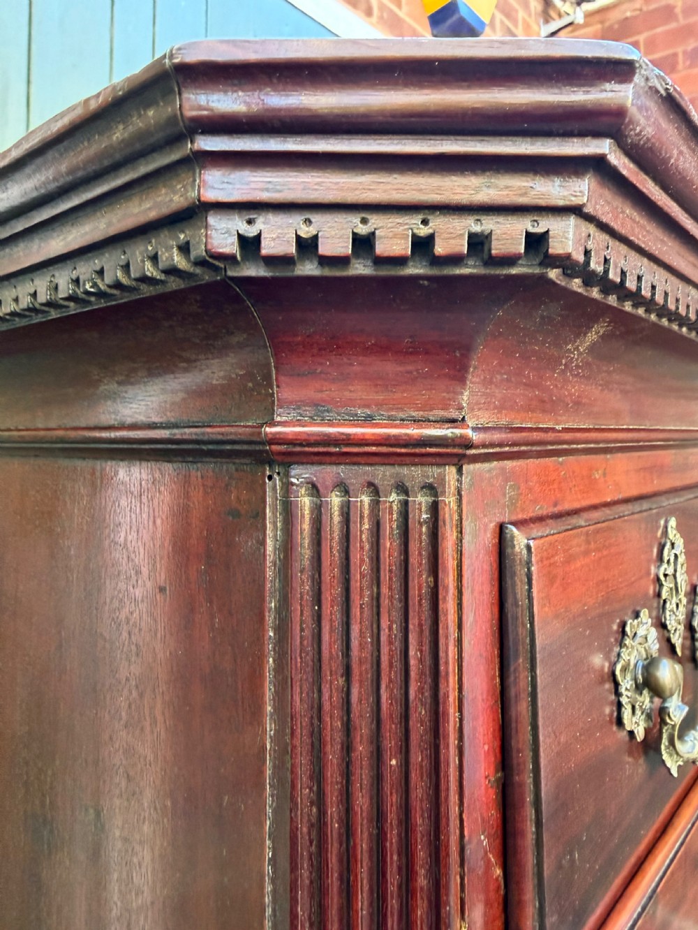 A mid-18th century George II red walnut chest-on-chest featuring a dentil moulded cornice, brass swan-neck handles, and bracket feet. View XVI