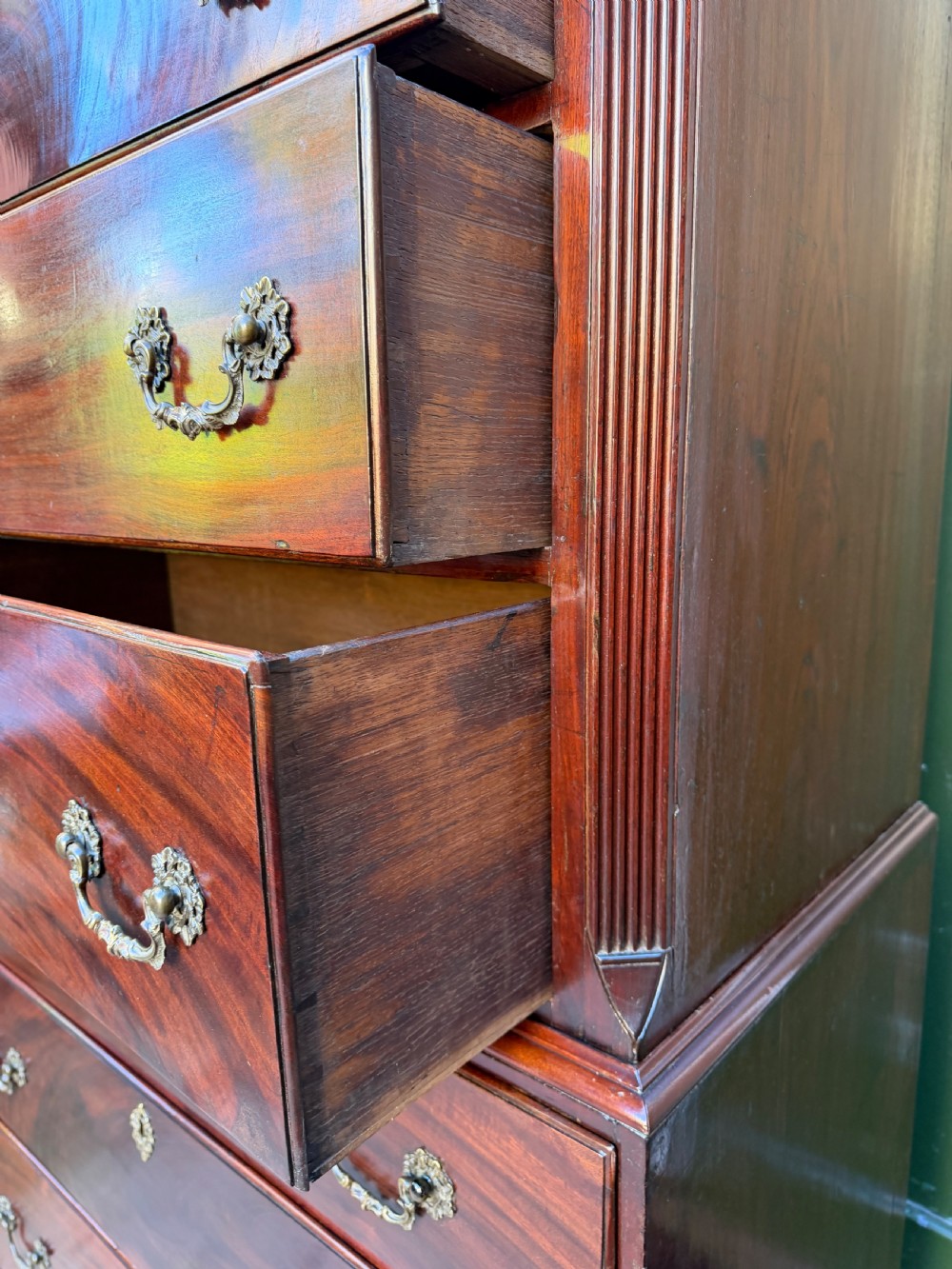 A mid-18th century George II red walnut chest-on-chest featuring a dentil moulded cornice, brass swan-neck handles, and bracket feet. View XX