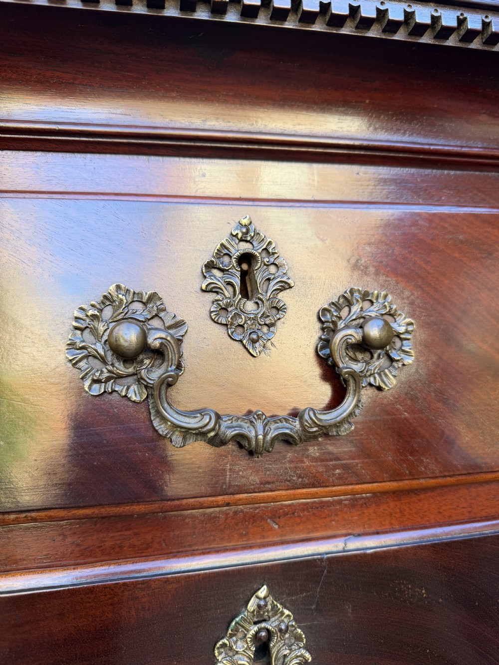 A mid-18th century George II red walnut chest-on-chest featuring a dentil moulded cornice, brass swan-neck handles, and bracket feet. View XXII
