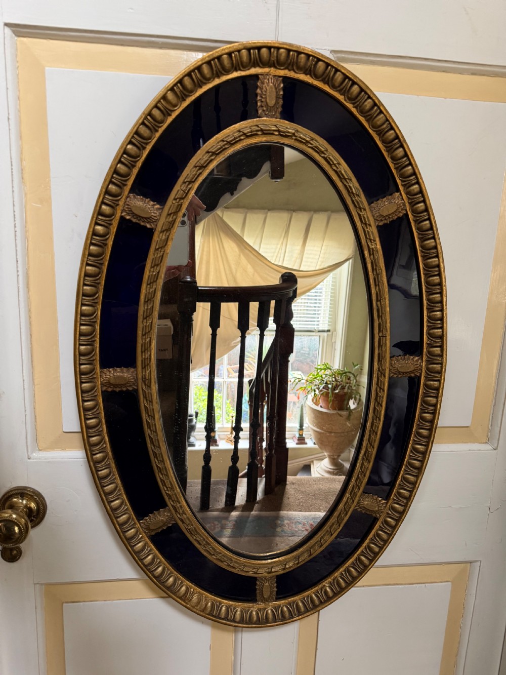 Decorative early C20th blue border glass oval gilt-wood framed mirror in the late C18th style .