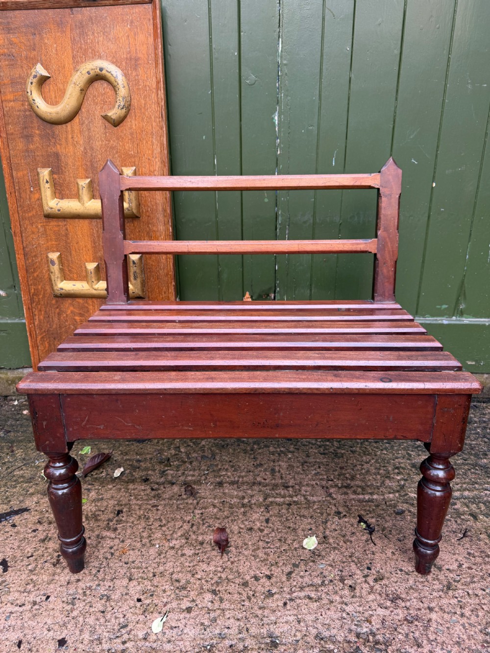 A mid-19th century mahogany luggage stand with a slatted platform, turned front legs, and a raised raked rear upstand. View III