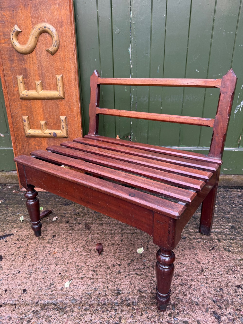 A mid-19th century mahogany luggage stand with a slatted platform, turned front legs, and a raised raked rear upstand. View V