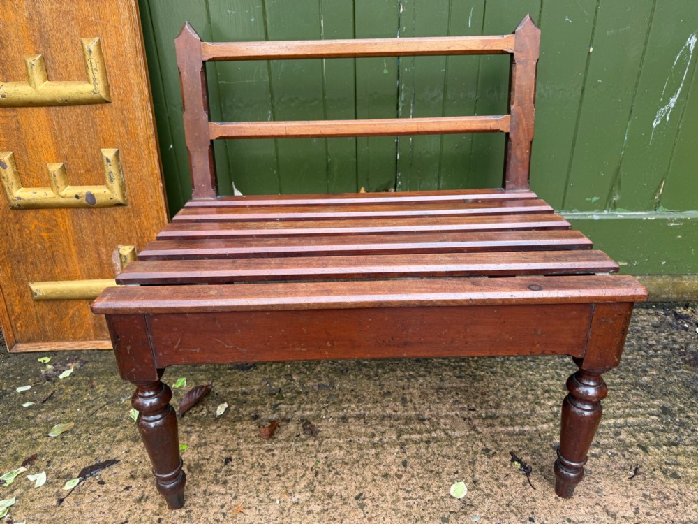 A mid-19th century mahogany luggage stand with a slatted platform, turned front legs, and a raised raked rear upstand. View VI