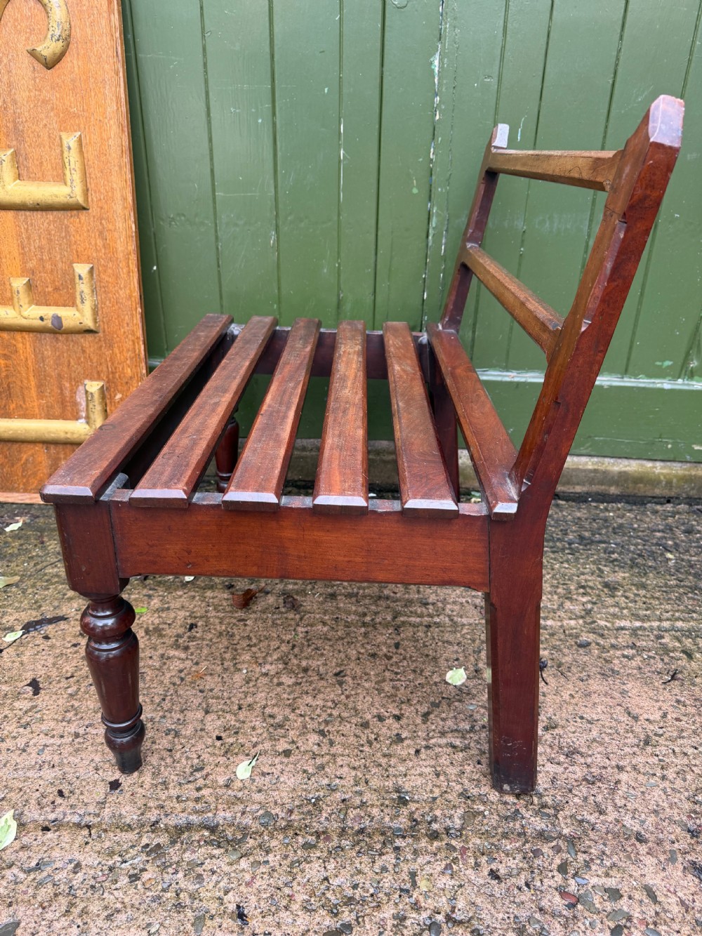 A mid-19th century mahogany luggage stand with a slatted platform, turned front legs, and a raised raked rear upstand. View VII