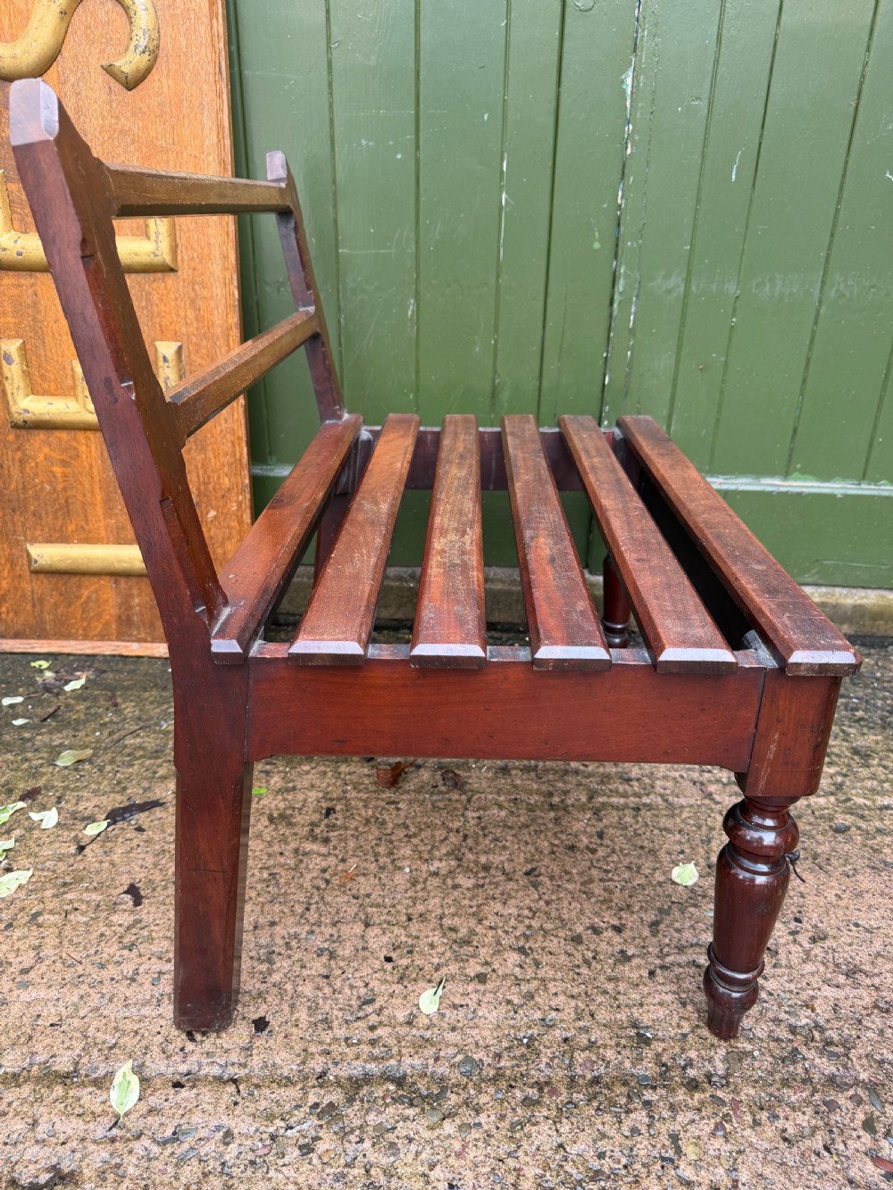 A mid-19th century mahogany luggage stand with a slatted platform, turned front legs, and a raised raked rear upstand. View XI