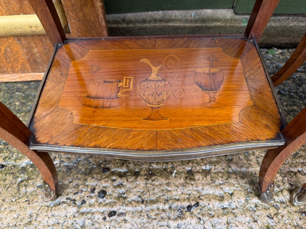 A pair of French marquetry bedside tables featuring three drawers with floral inlays, brass mounts, curved legs, and a lower tier shelf. View IX