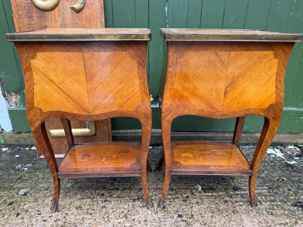 A pair of French marquetry bedside tables featuring three drawers with floral inlays, brass mounts, curved legs, and a lower tier shelf. View XII