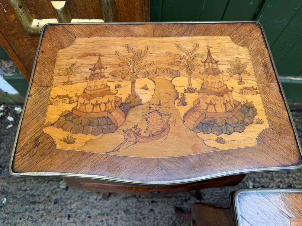 A pair of French marquetry bedside tables featuring three drawers with floral inlays, brass mounts, curved legs, and a lower tier shelf. View XVII