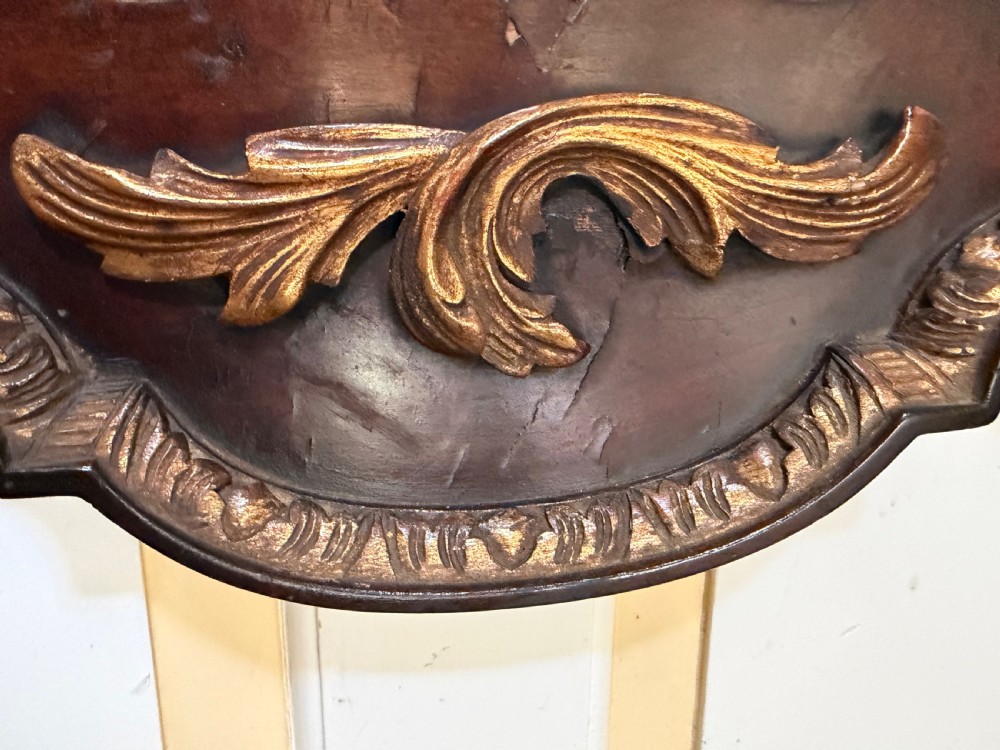 A George II style walnut wall mirror featuring a carved parcel gilt frame with a swan-neck pediment and central cartouche cresting. View XI