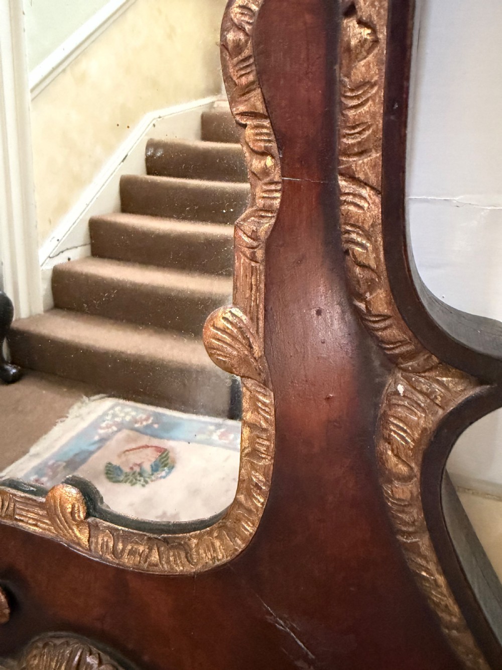A George II style walnut wall mirror featuring a carved parcel gilt frame with a swan-neck pediment and central cartouche cresting. View XII