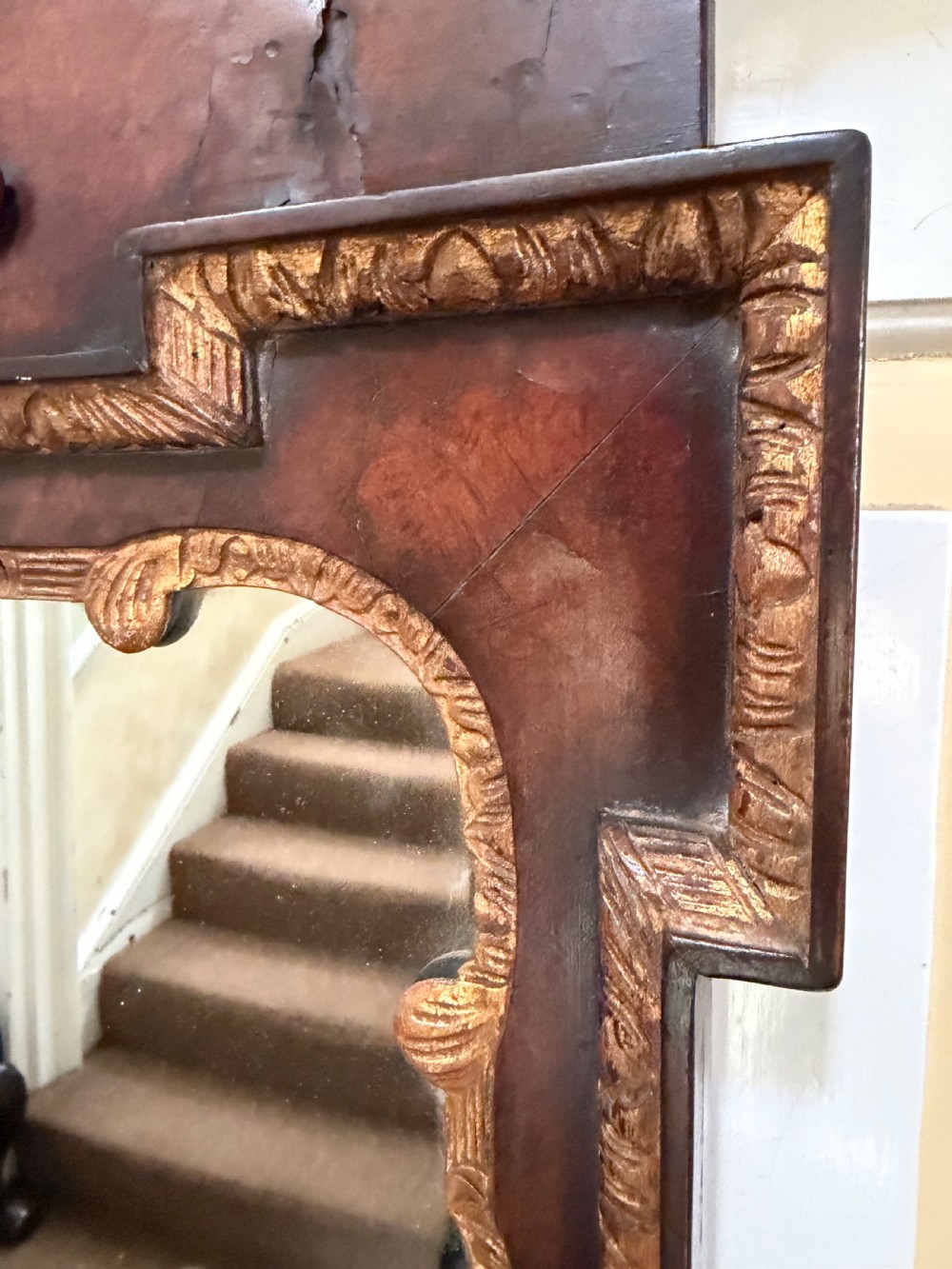 A George II style walnut wall mirror featuring a carved parcel gilt frame with a swan-neck pediment and central cartouche cresting. View XIII