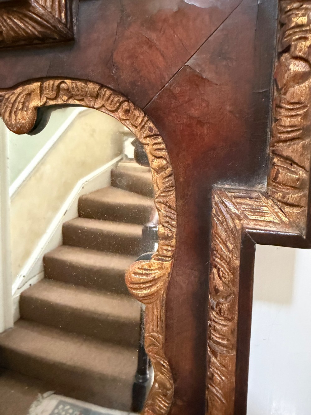 A George II style walnut wall mirror featuring a carved parcel gilt frame with a swan-neck pediment and central cartouche cresting. View XV