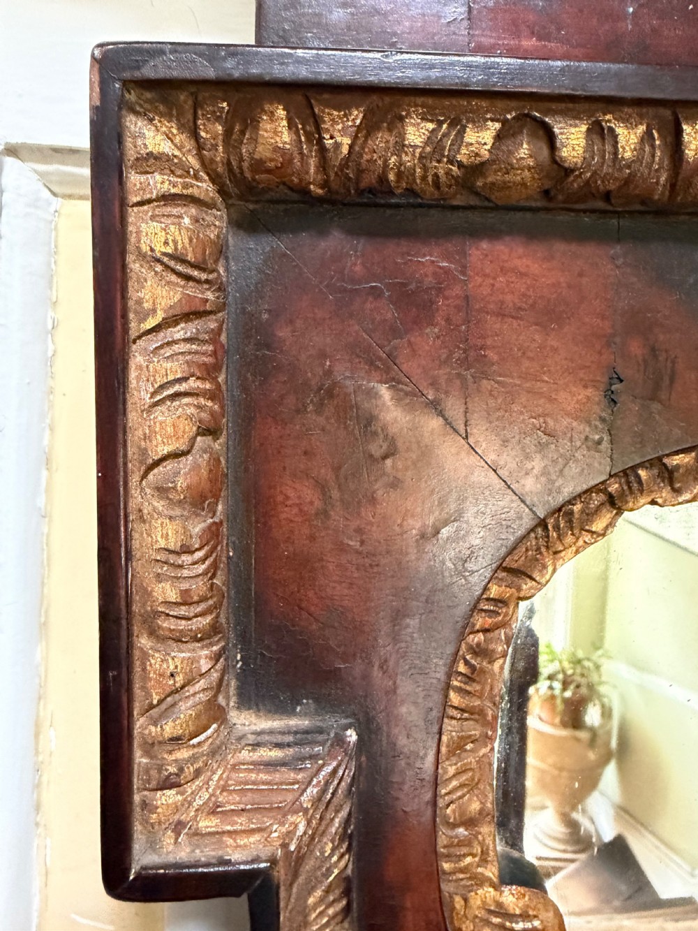 A George II style walnut wall mirror featuring a carved parcel gilt frame with a swan-neck pediment and central cartouche cresting. View XIX