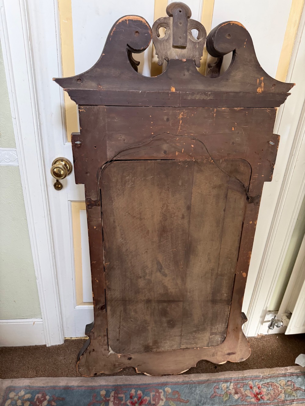 A George II style walnut wall mirror featuring a carved parcel gilt frame with a swan-neck pediment and central cartouche cresting. View XX