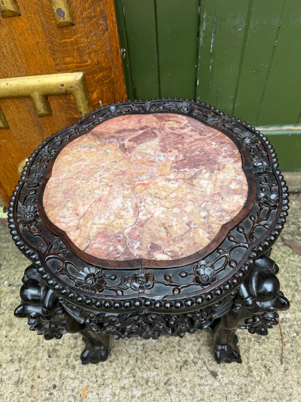 A late nineteenth-century Chinese carved dark hardwood jardiniere stand featuring a circular inset pink variegated marble top, intricate pierced floral aprons, and carved cabriole legs. View II