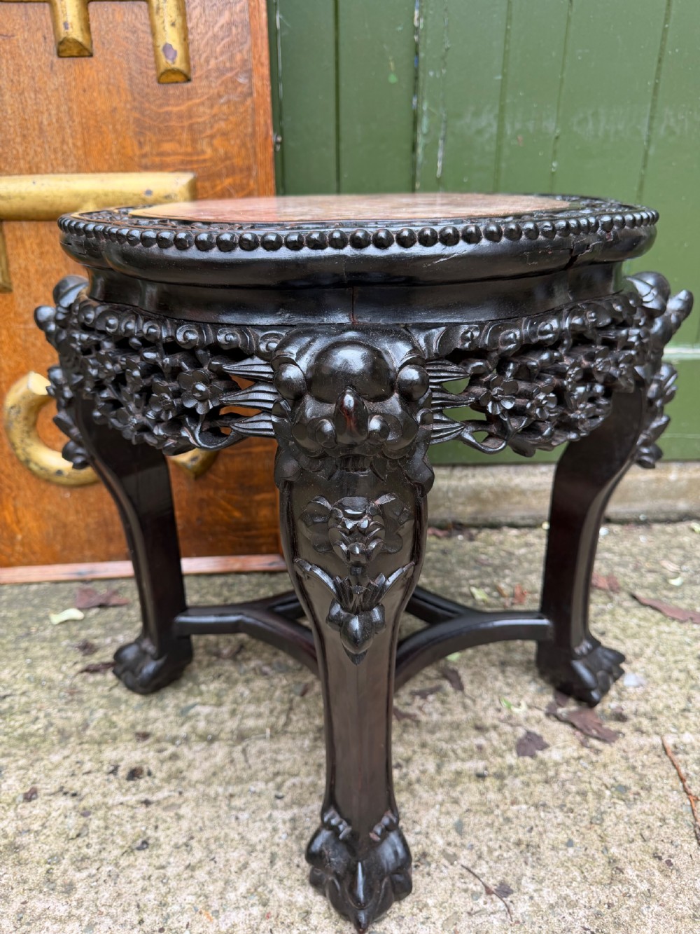 A late nineteenth-century Chinese carved dark hardwood jardiniere stand featuring a circular inset pink variegated marble top, intricate pierced floral aprons, and carved cabriole legs. View III