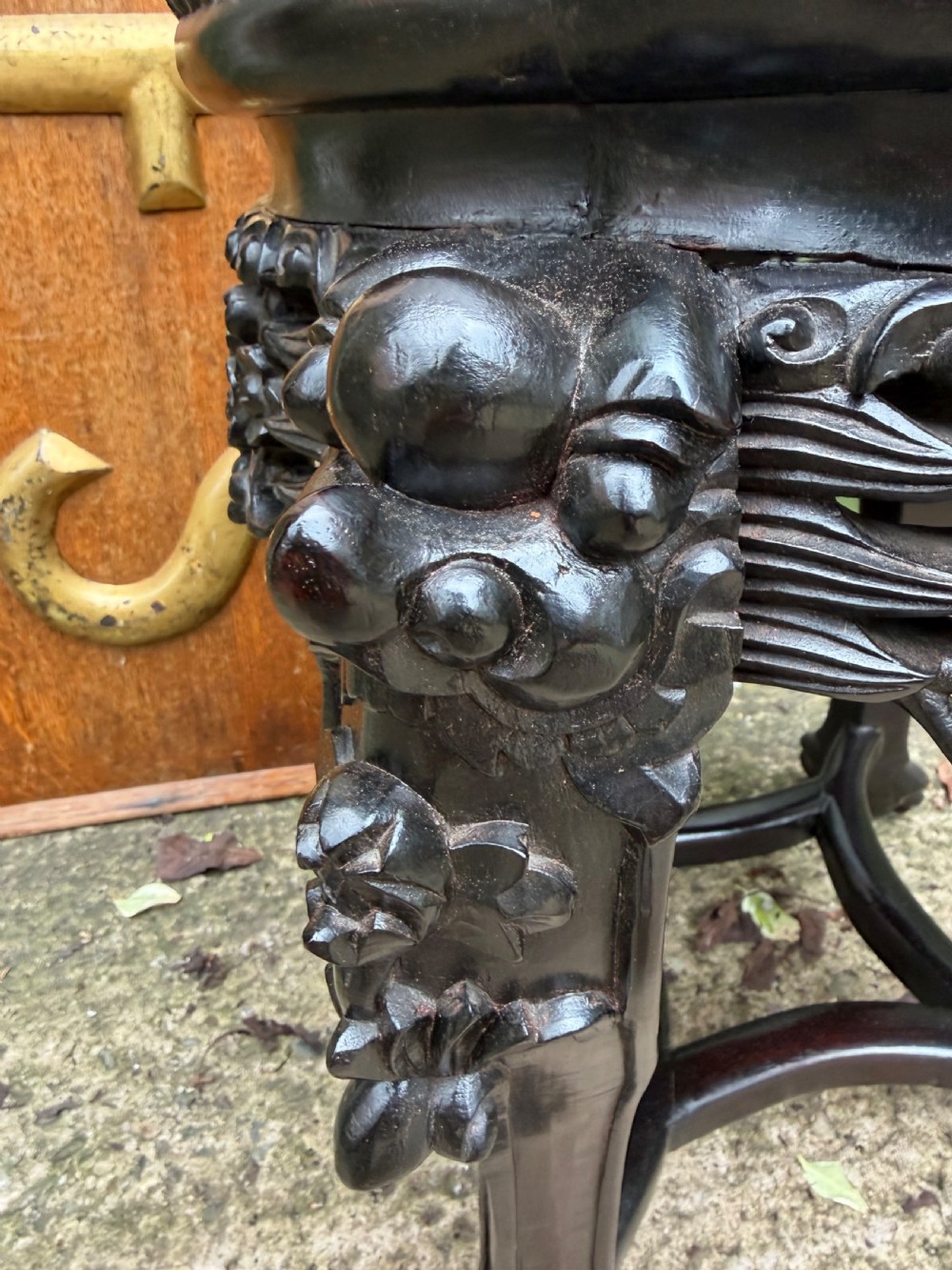 A late nineteenth-century Chinese carved dark hardwood jardiniere stand featuring a circular inset pink variegated marble top, intricate pierced floral aprons, and carved cabriole legs. View IV
