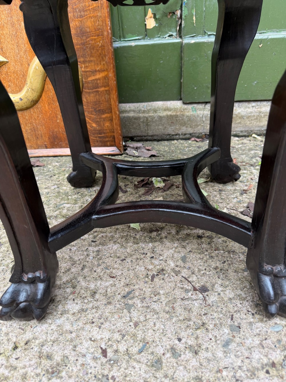 A late nineteenth-century Chinese carved dark hardwood jardiniere stand featuring a circular inset pink variegated marble top, intricate pierced floral aprons, and carved cabriole legs. View X