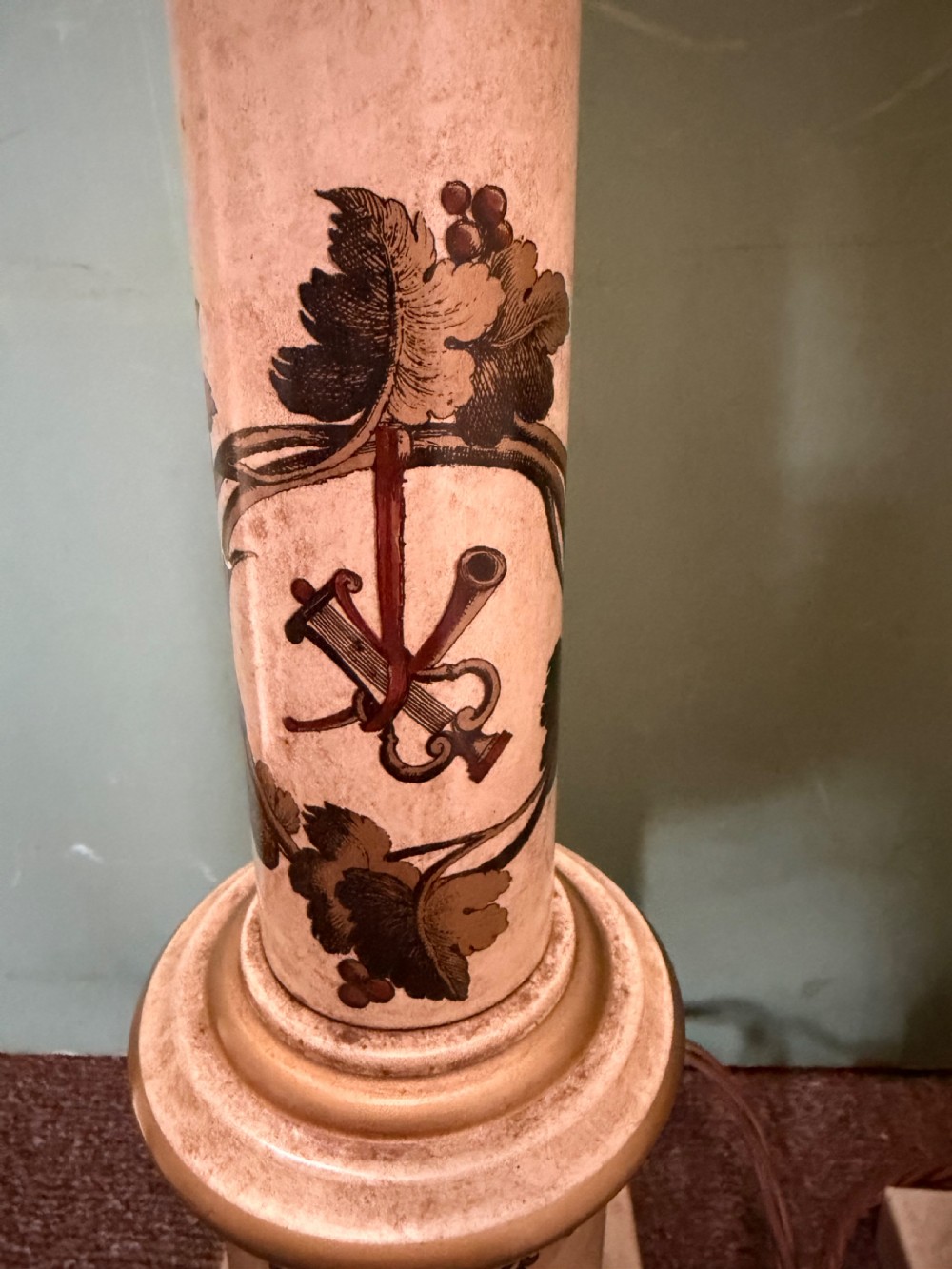 A pair of early twentieth-century French cream tole-peinte column table lamps decorated with hand-painted vine leaves, musical motifs, and gilt trim. View II