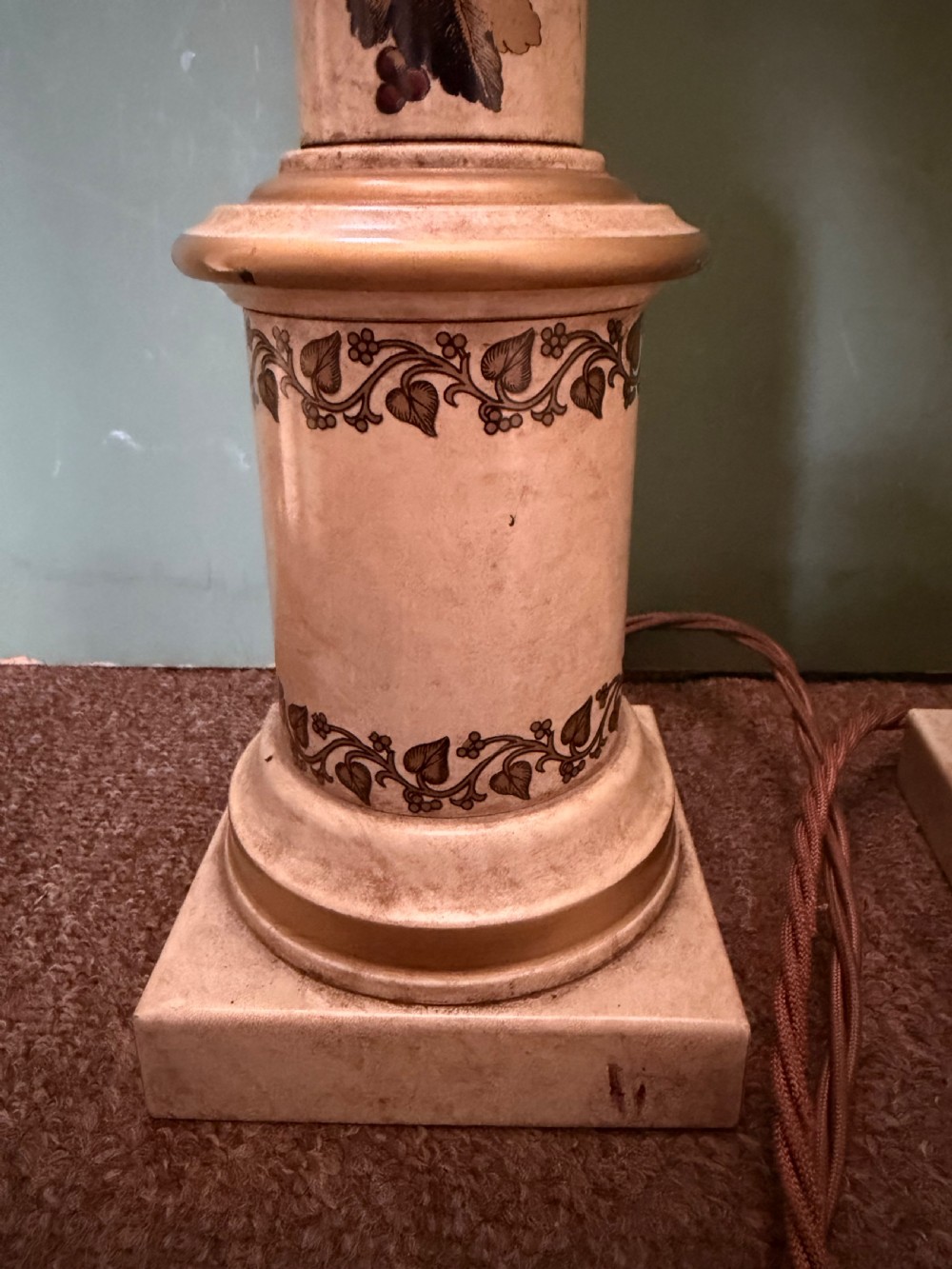 A pair of early twentieth-century French cream tole-peinte column table lamps decorated with hand-painted vine leaves, musical motifs, and gilt trim. View V