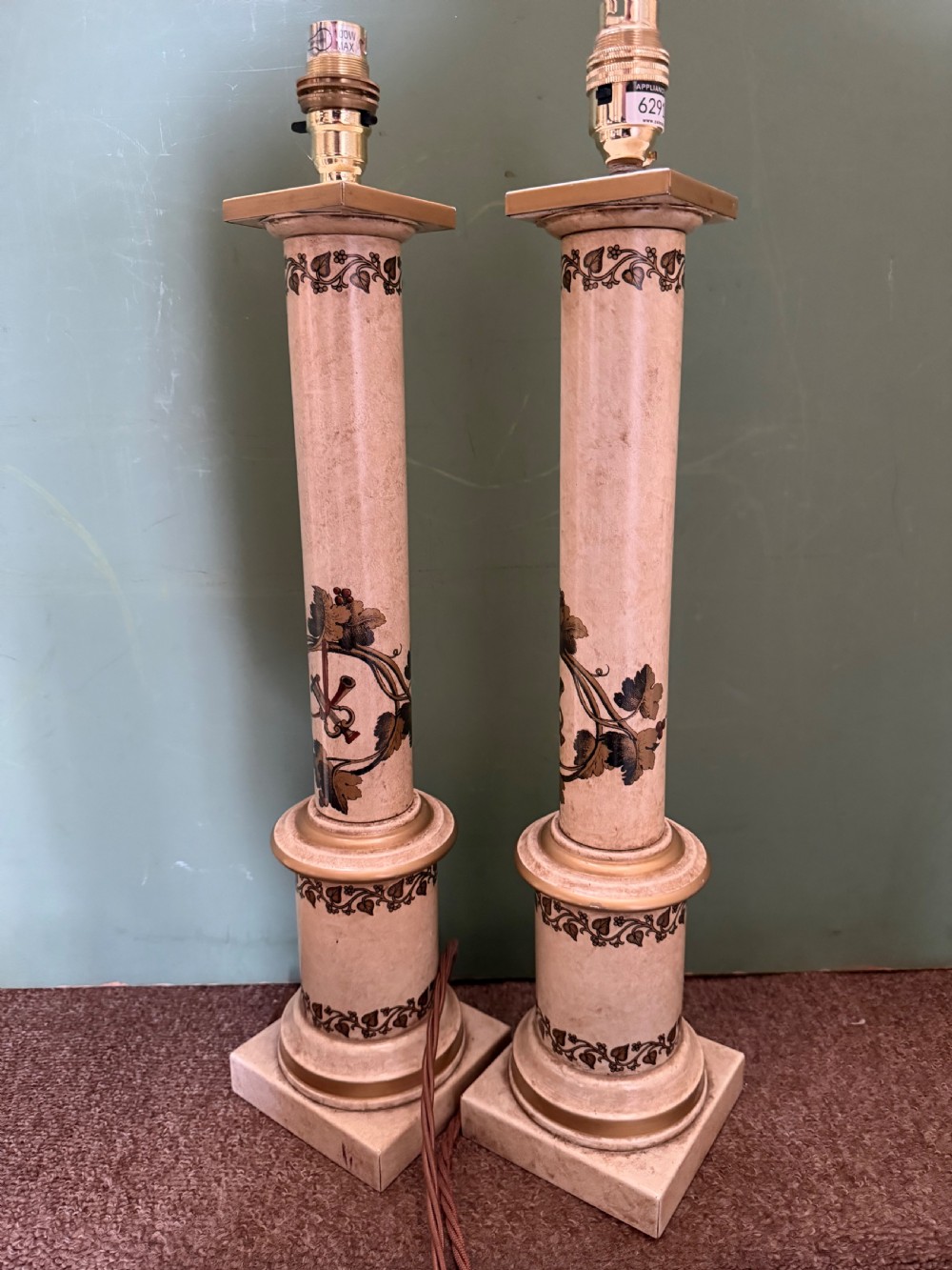 A pair of early twentieth-century French cream tole-peinte column table lamps decorated with hand-painted vine leaves, musical motifs, and gilt trim. View X