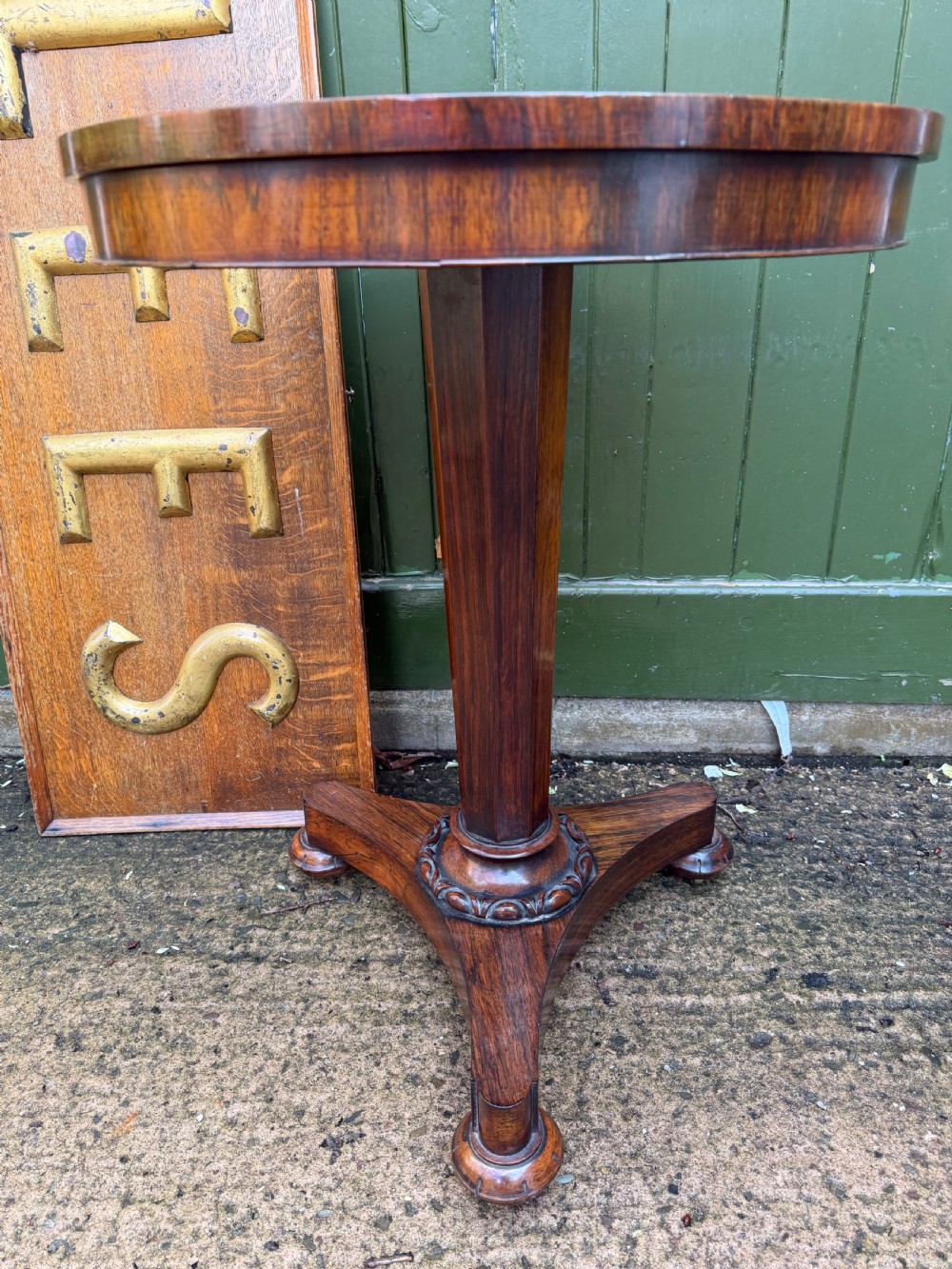 An early nineteenth-century circular rosewood occasional table featuring a deep apron, a faceted central pedestal, and a triform base with carved detail. View VI