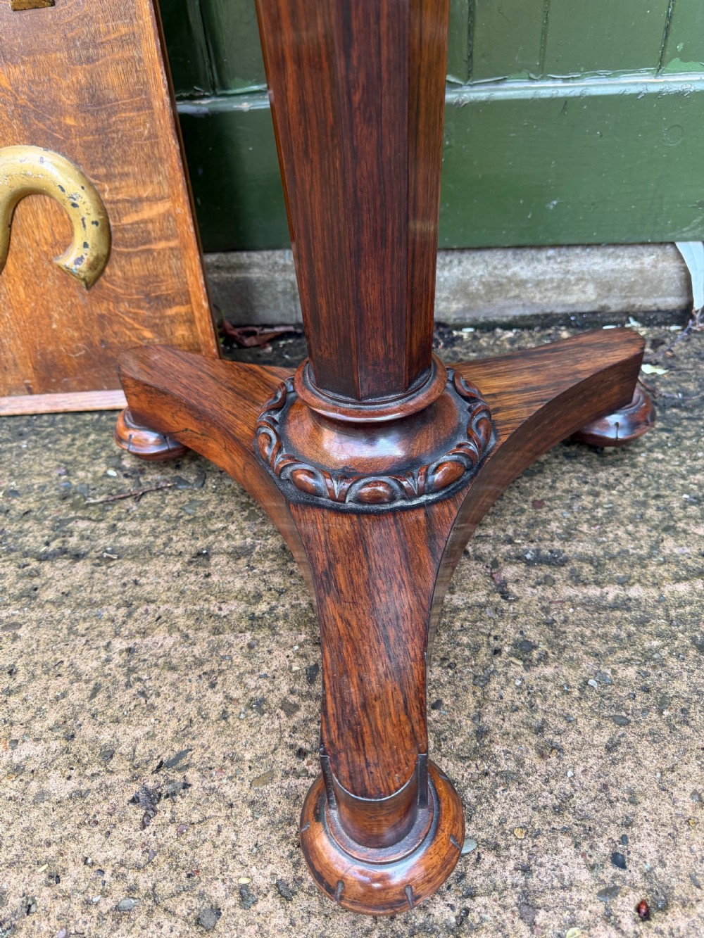 An early nineteenth-century circular rosewood occasional table featuring a deep apron, a faceted central pedestal, and a triform base with carved detail. View VII