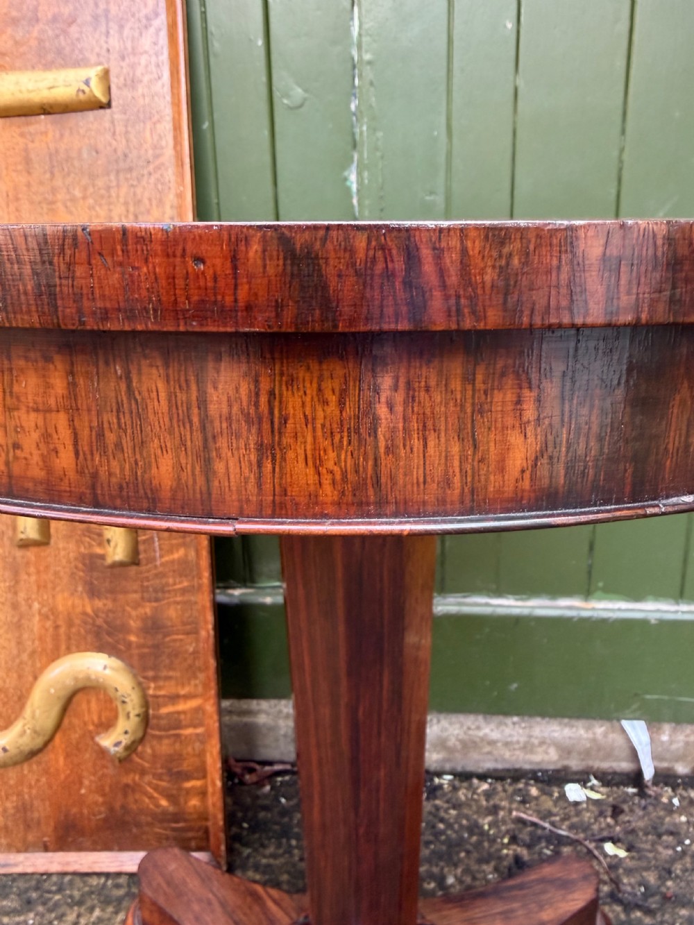 An early nineteenth-century circular rosewood occasional table featuring a deep apron, a faceted central pedestal, and a triform base with carved detail. View IX