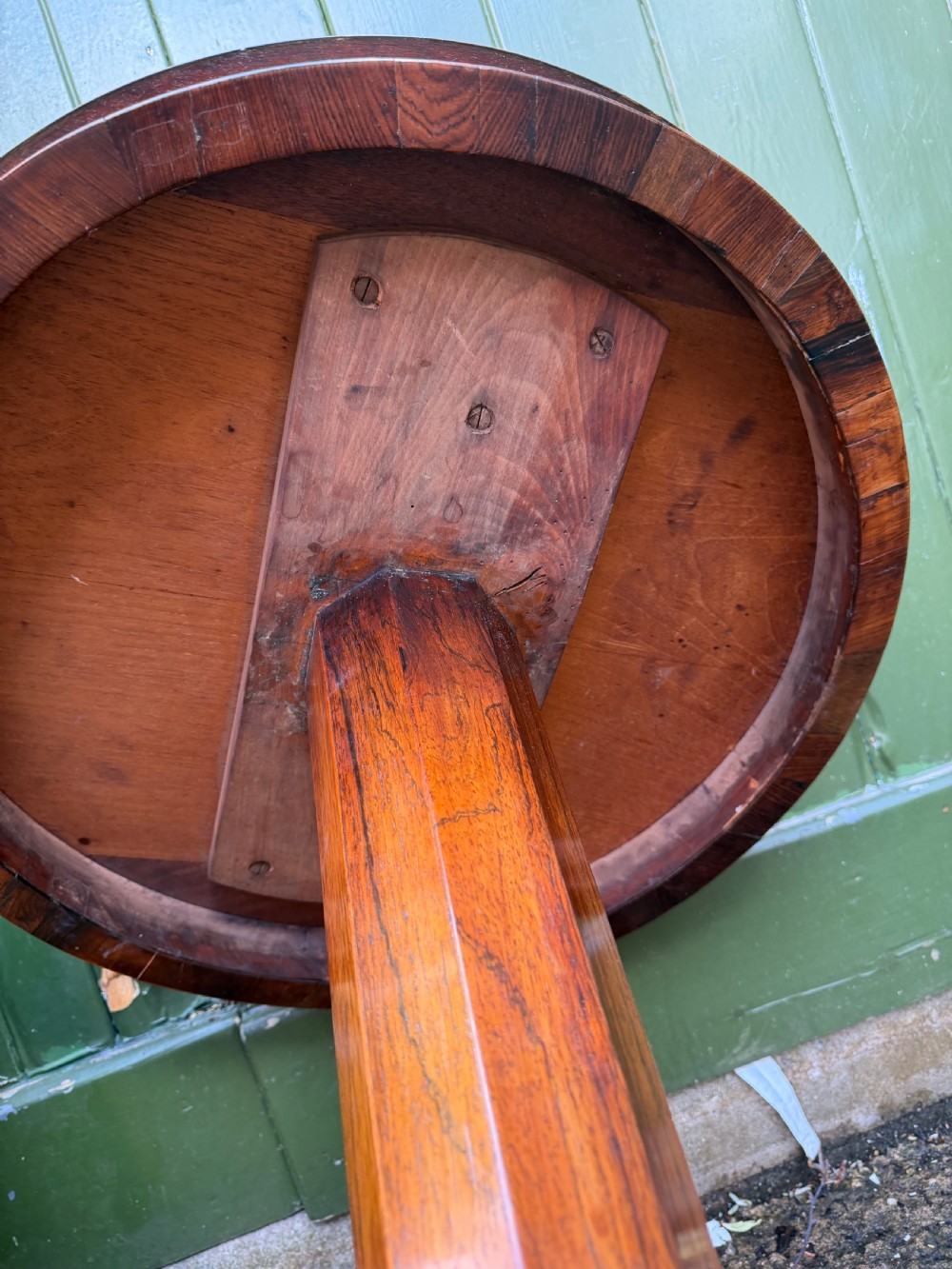 An early nineteenth-century circular rosewood occasional table featuring a deep apron, a faceted central pedestal, and a triform base with carved detail. View XII