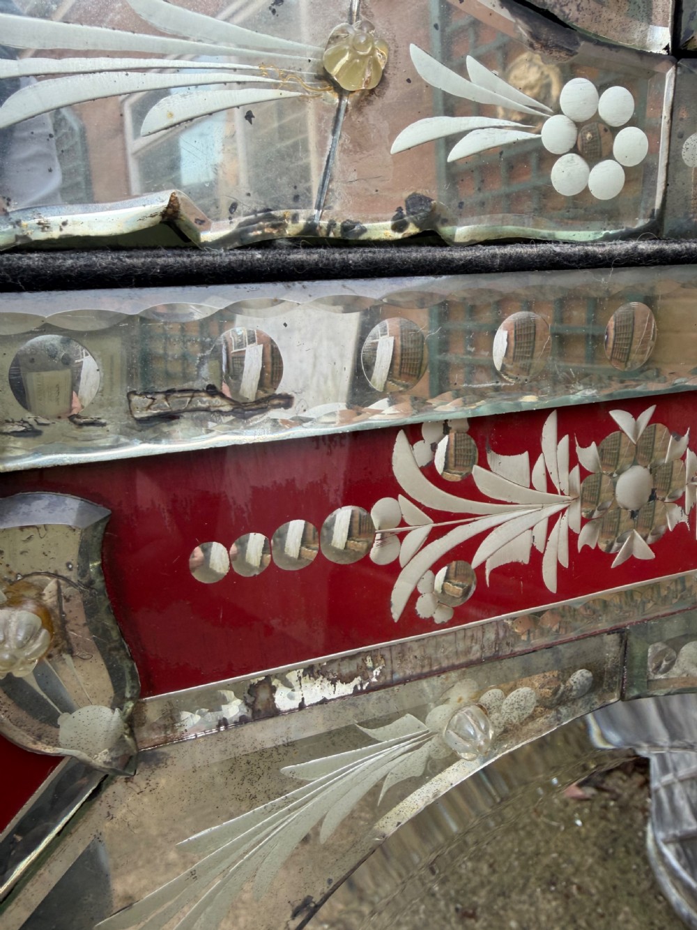 An antique Venetian wall mirror featuring cut and etched glass borders with ruby red glass accents and a decorative pediment crest. View VIII