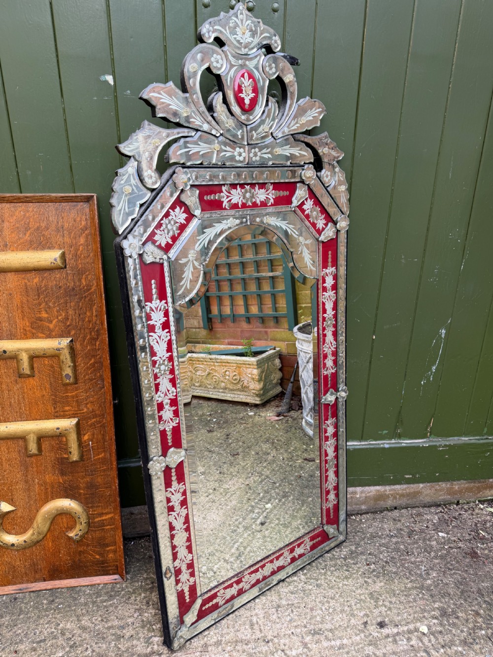 An antique Venetian wall mirror featuring cut and etched glass borders with ruby red glass accents and a decorative pediment crest. View XIII