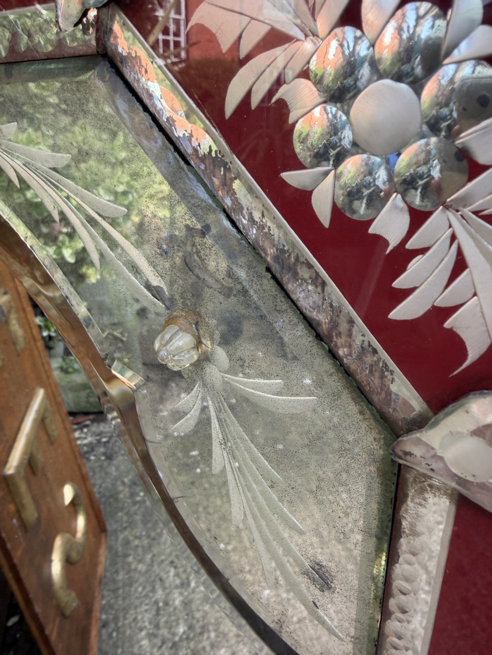 An antique Venetian wall mirror featuring cut and etched glass borders with ruby red glass accents and a decorative pediment crest. View XX